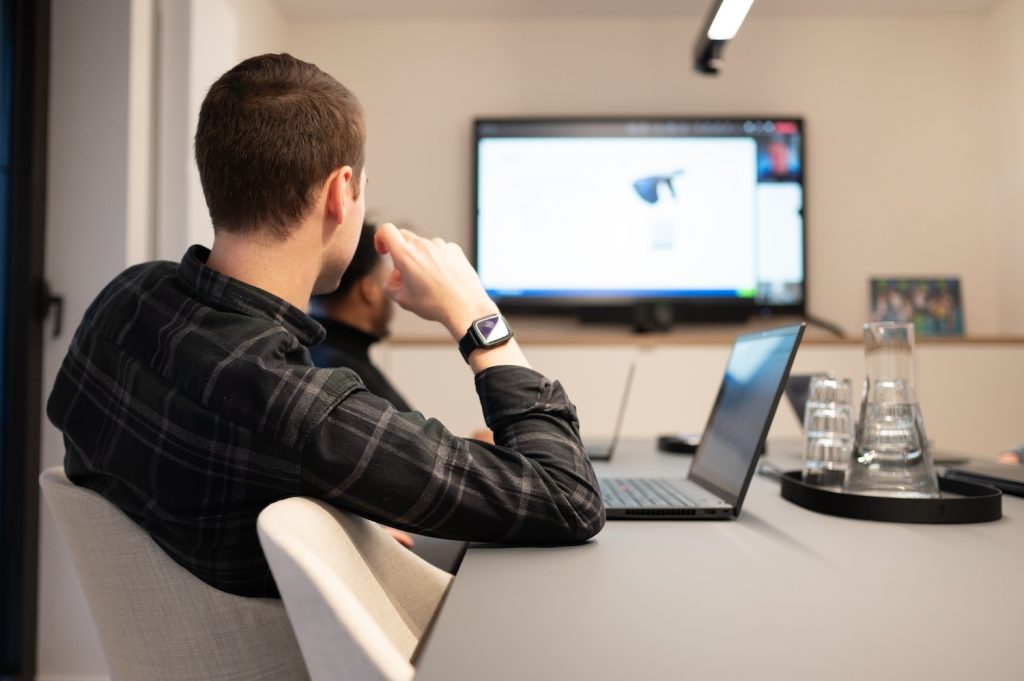 Foto van collega's die een meeting hebben waarbij mensen vanop een andere locatie inbellen